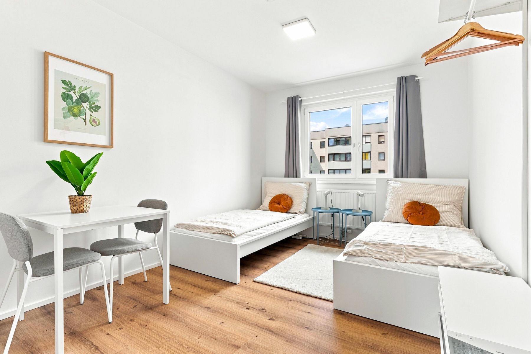 Helles Zimmer mit Bett, Schreibtisch und Blick ins Grüne