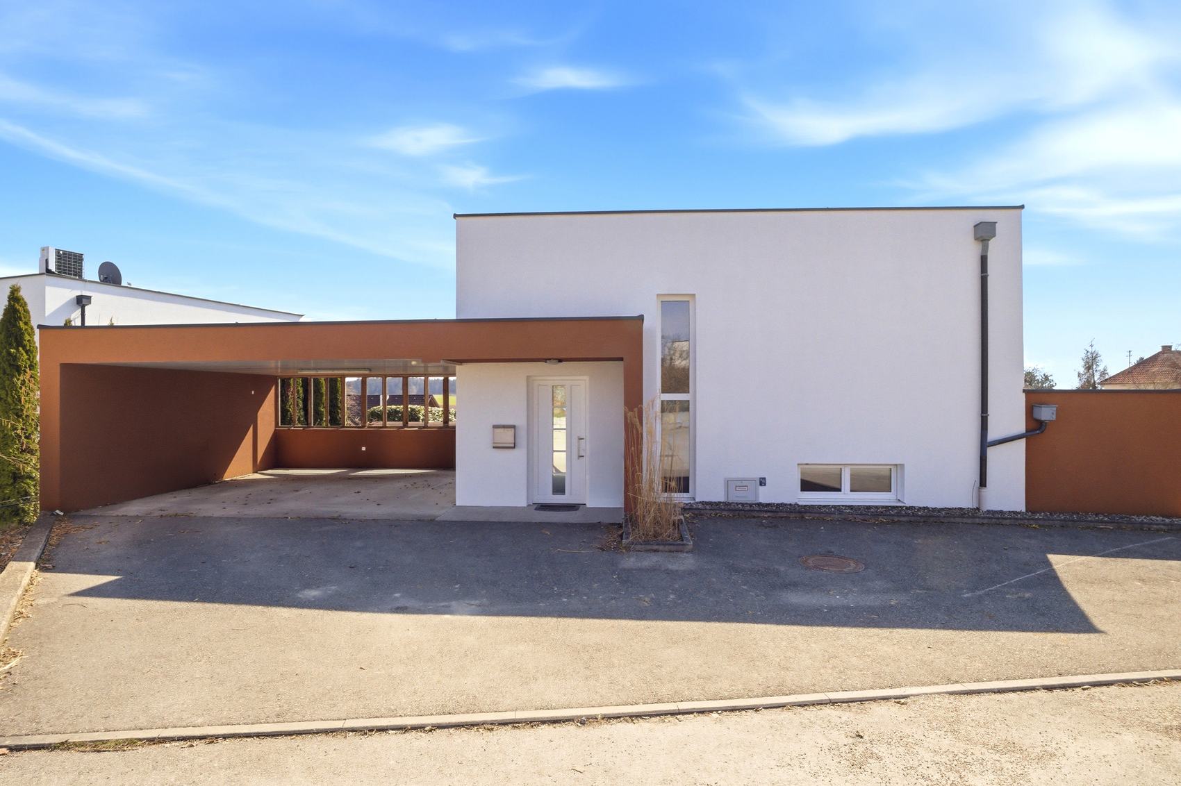 Weißes Haus mit Carport und Einfahrt